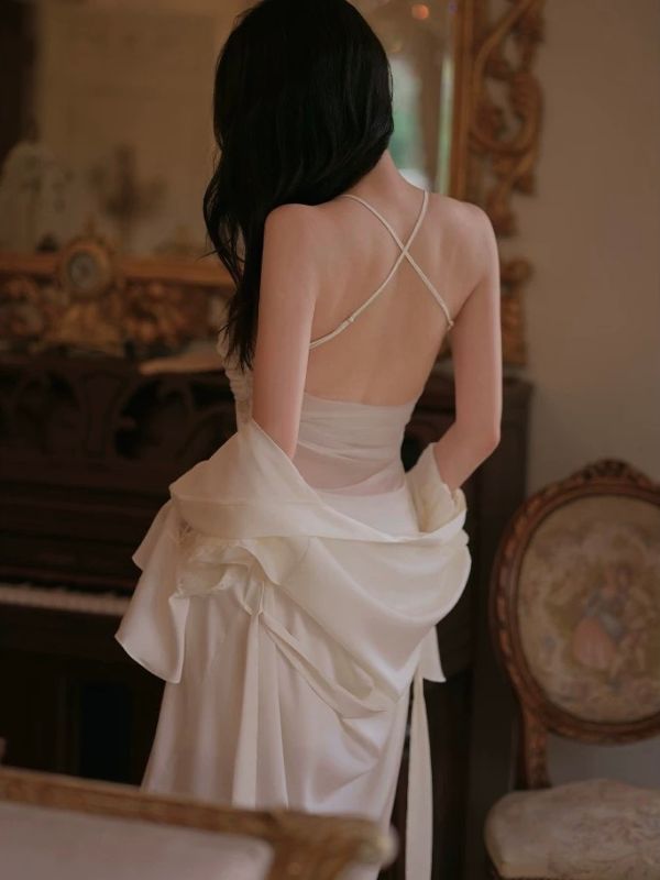 Woman in a white dress with a backless design in an indoor setting