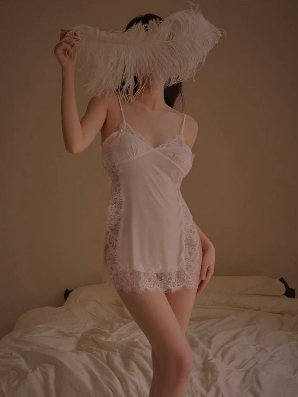 Person wearing a white lace nightgown in a bedroom setting.