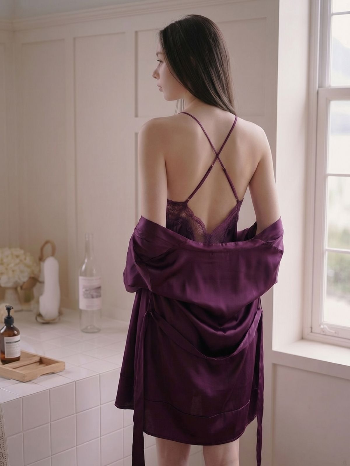 Woman wearing a purple satin robe in a bathroom.