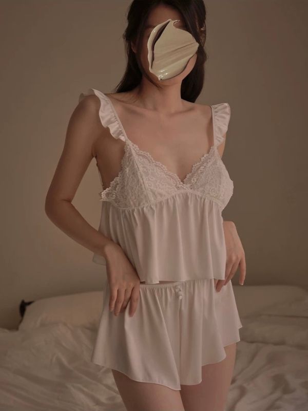 Person wearing a white lace nightgown with a plain background