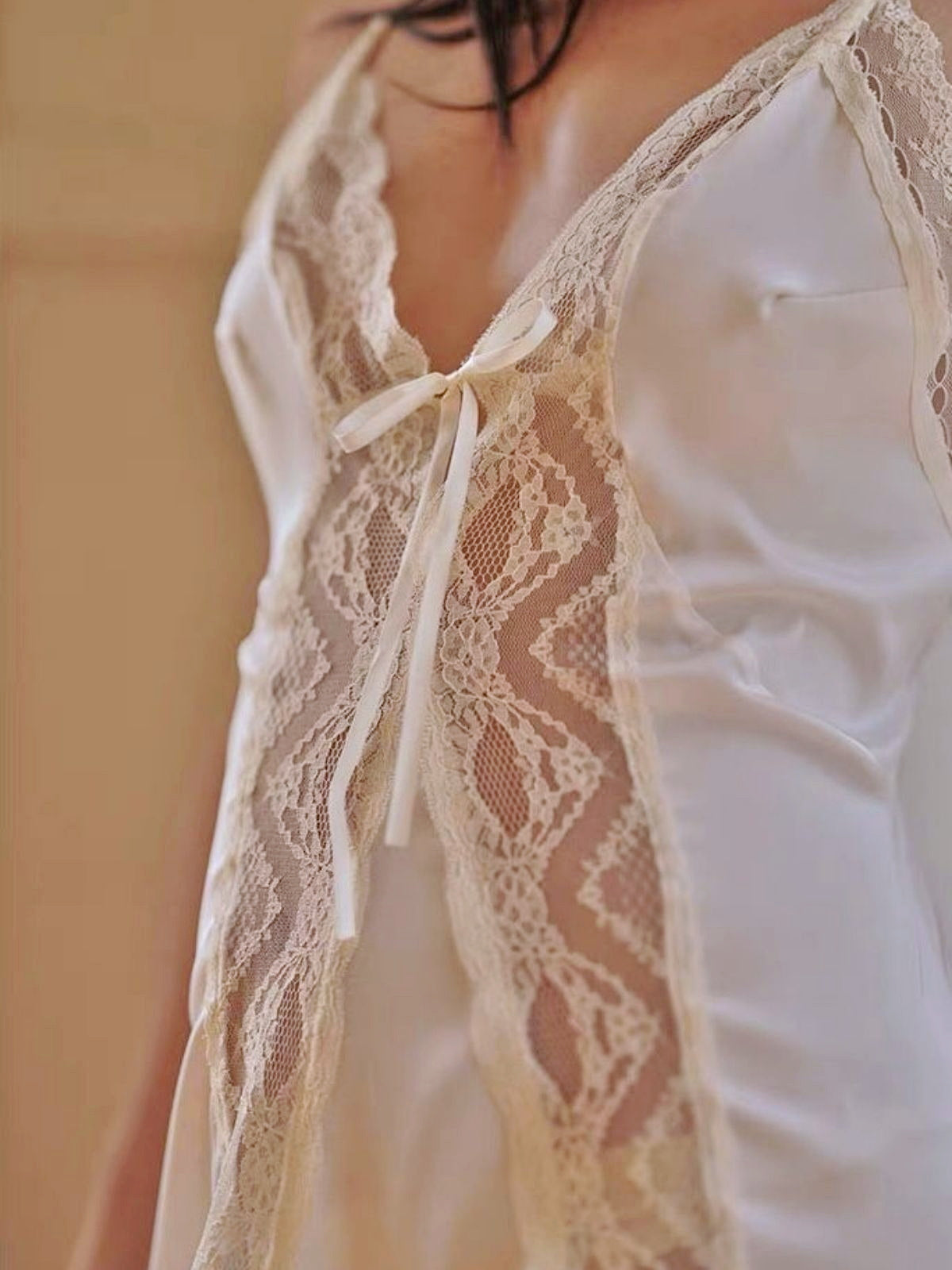 White lace-trimmed top with a blurred background