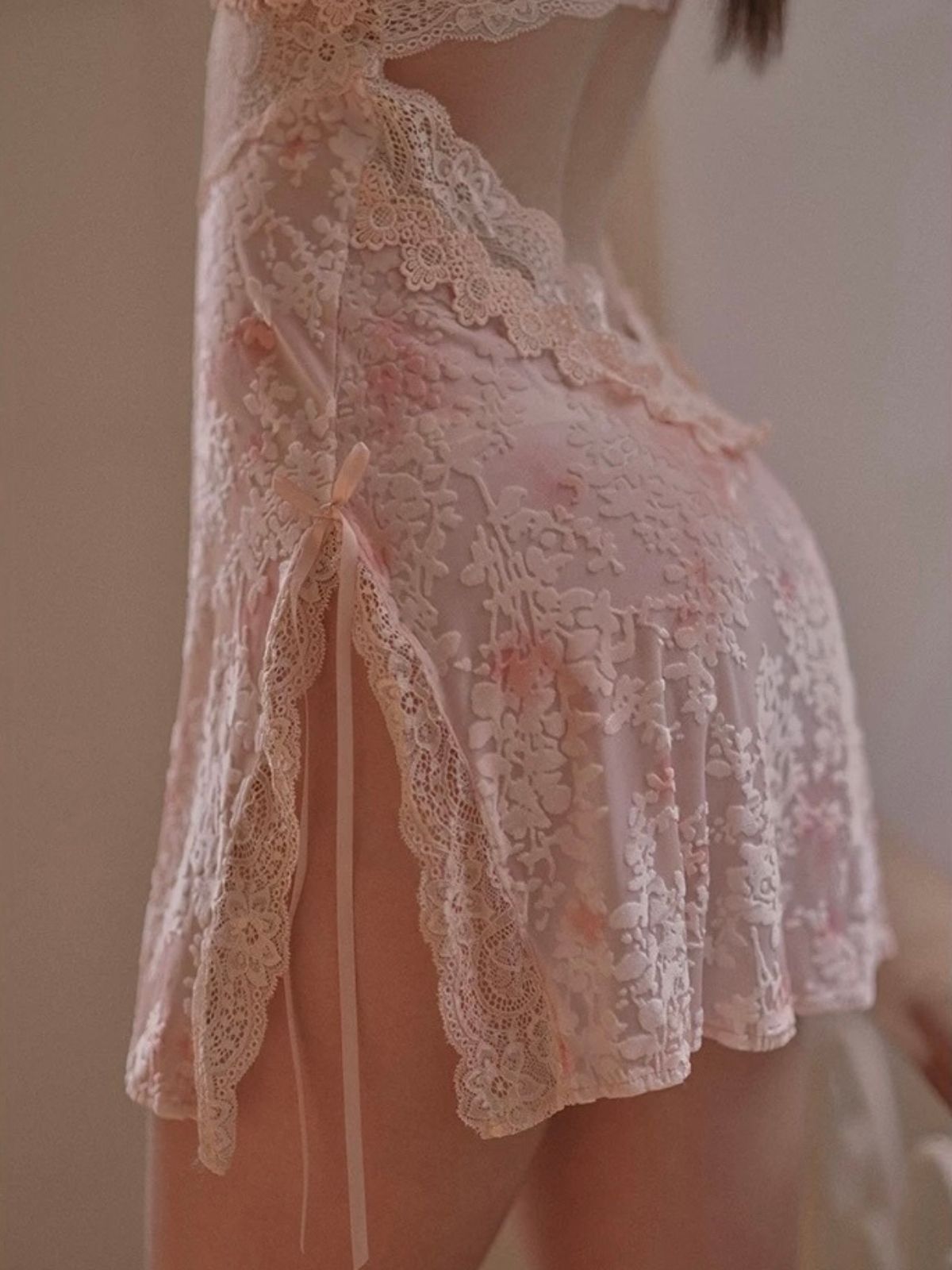 Woman wearing a pink lace nightgown  in velvet material.