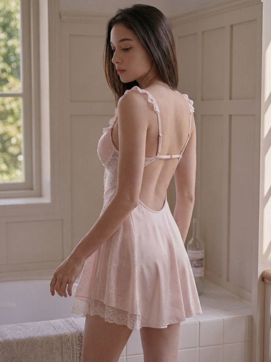 Woman wearing a delicate pink lace nightgown in a softly lit room.